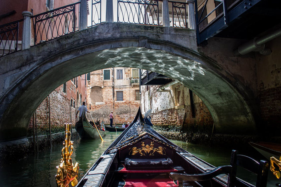 Una gondola passa sotto un ponte in pietra a Venezia.